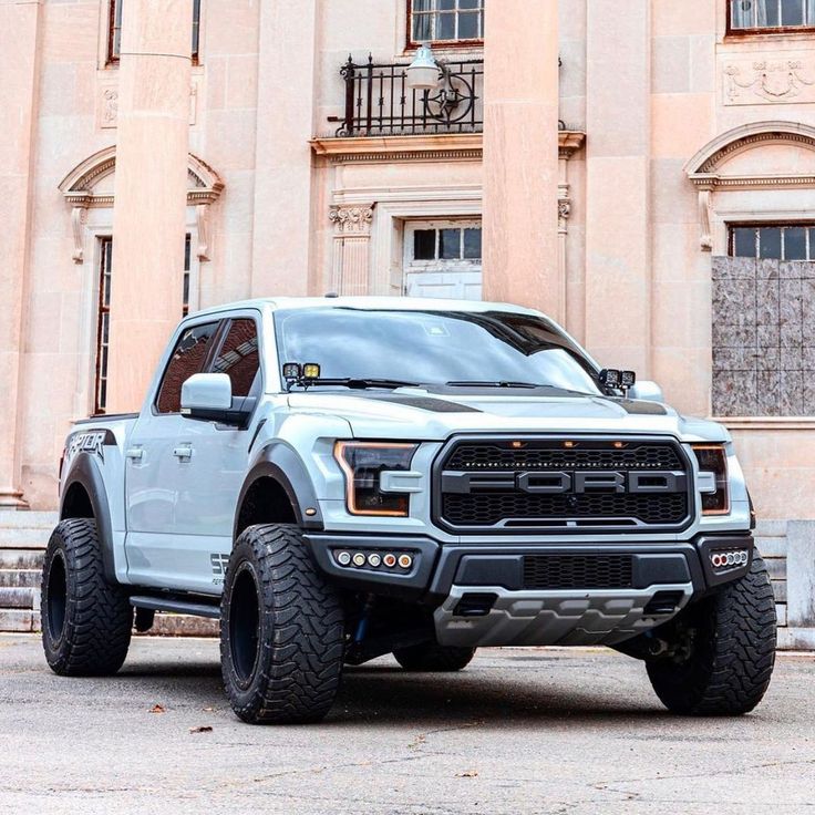 a white truck parked in front of a large building