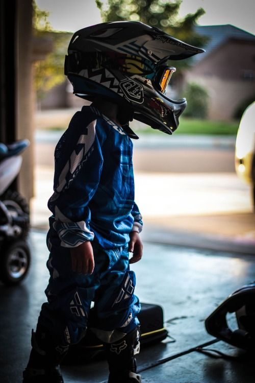 a young boy wearing a helmet and riding on a skateboard