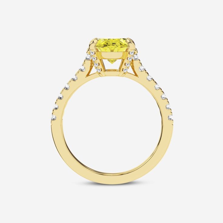 a yellow diamond ring with white diamonds on the sides and an oval shaped center stone