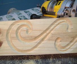 a close up of a piece of wood with a machine in the background