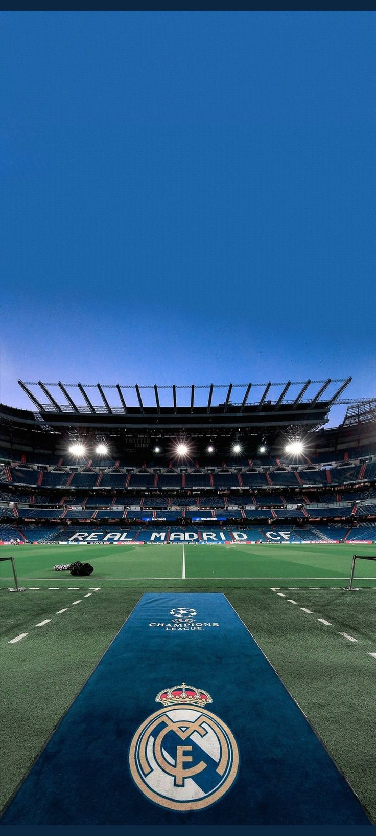 an empty soccer field at night with the lights on