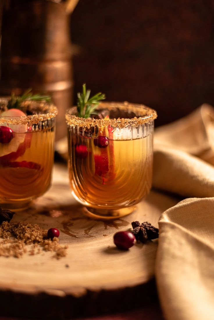 two glasses filled with drinks sitting on top of a table