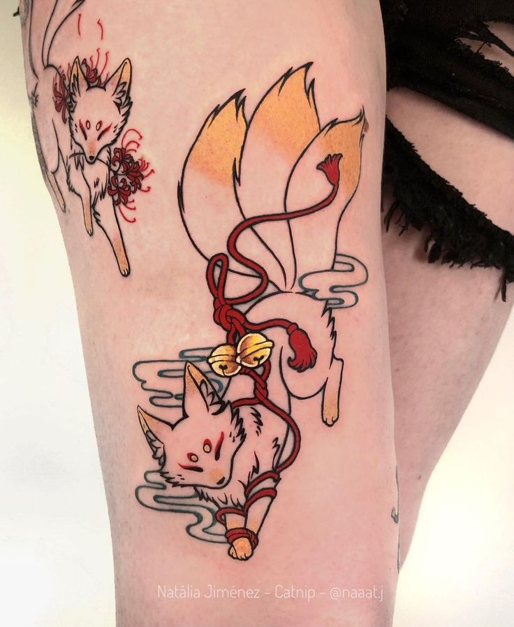 a woman's leg with tattoos on it and an image of two cats in the water