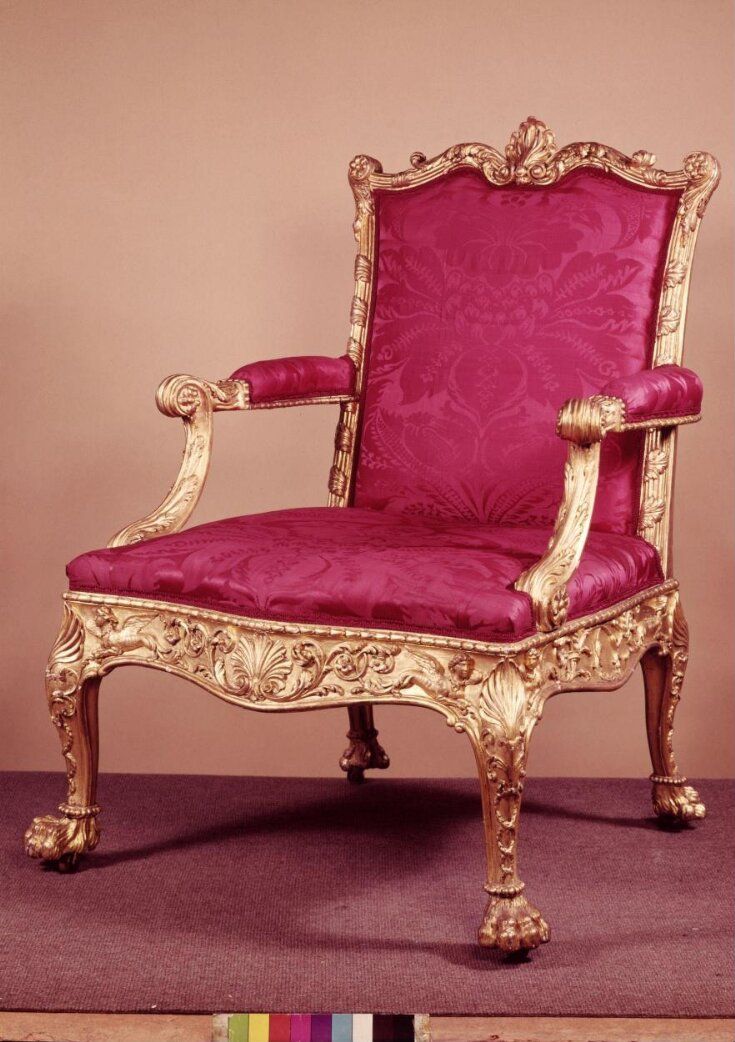 an ornately decorated chair with pink velvet upholstered on the back and arms