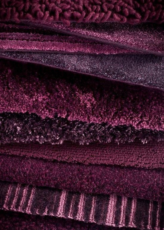 a pile of towels stacked on top of each other in purple and black colors,