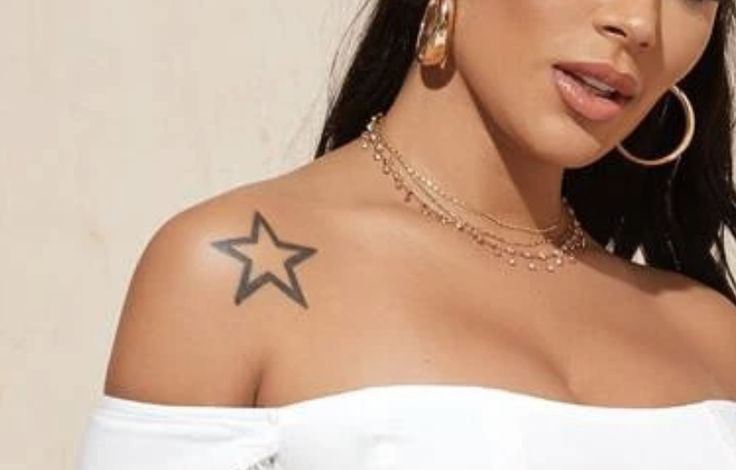 a close up of a person wearing large hoop earrings and a white shirt with stars on it