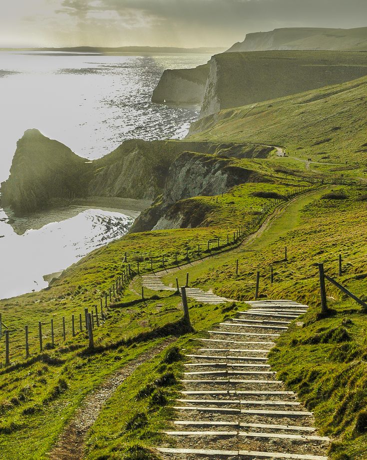 there are many steps that lead up to the water's edge on this grassy hill