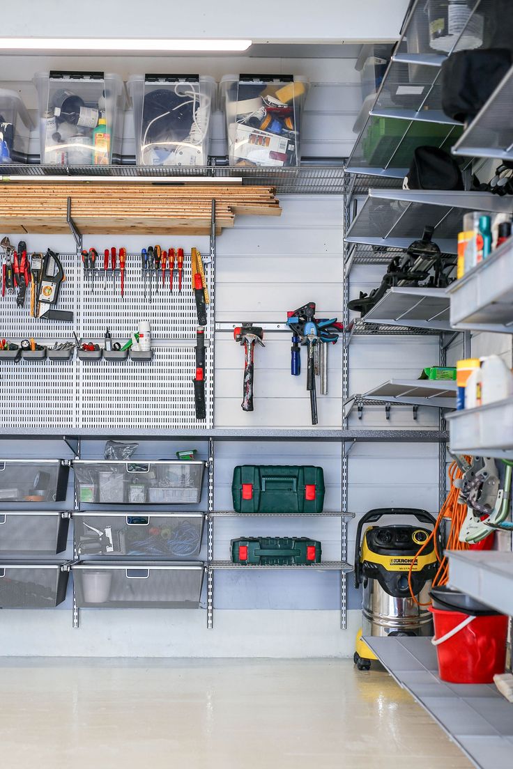 a garage filled with lots of tools and storage bins on the wall next to each other