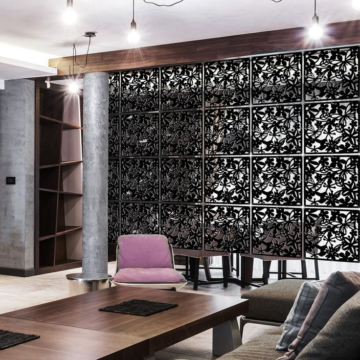 a living room filled with furniture next to a tall wooden table and bookshelf