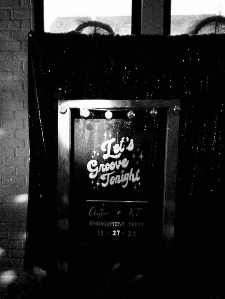 a black and white photo of a sign in front of a brick wall that says it's creative tonight