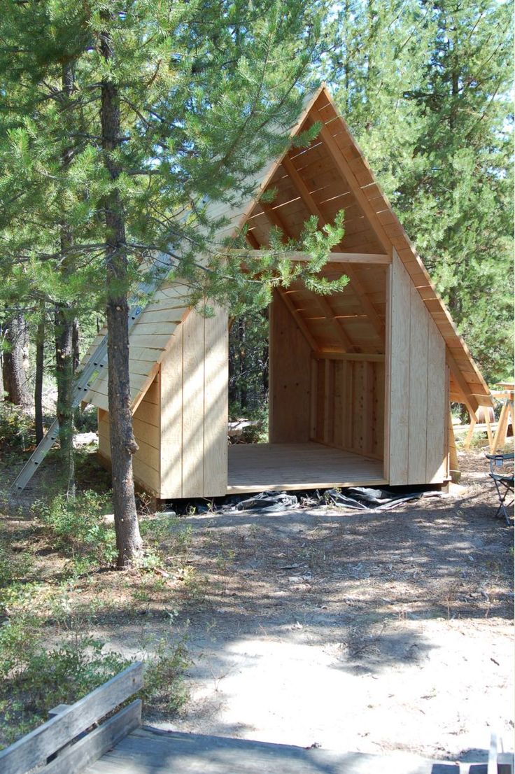 a small wooden cabin in the woods surrounded by trees