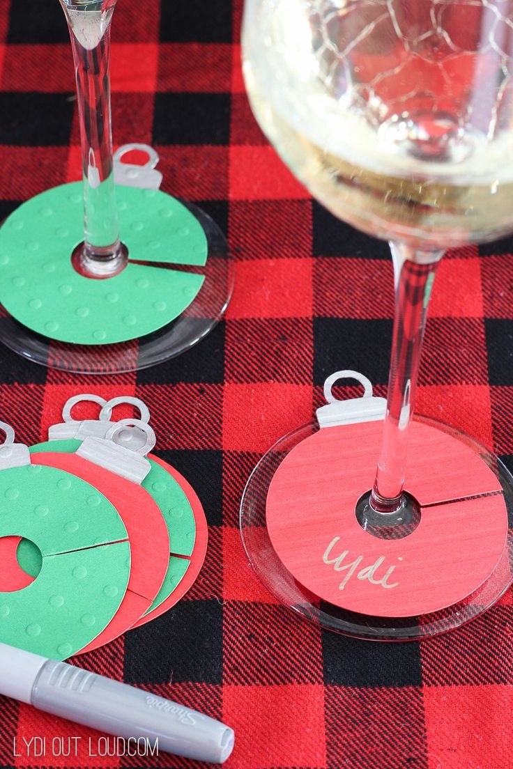 four wine glasses with paper circles on them sitting on top of a table next to a bottle of wine