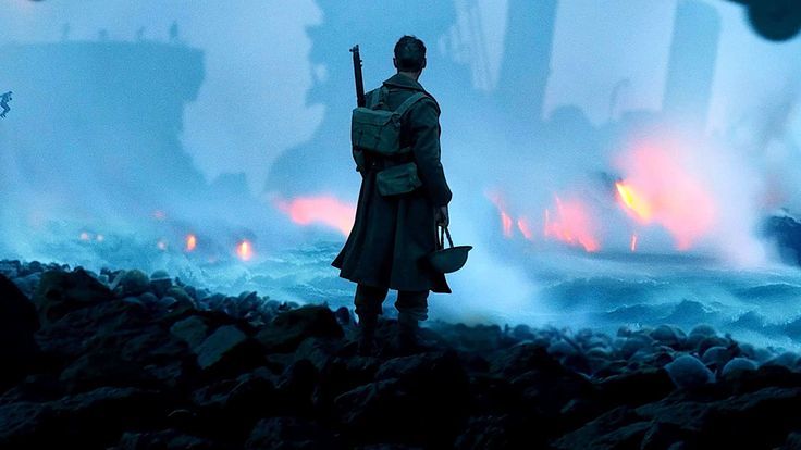 a man standing on top of a rocky beach