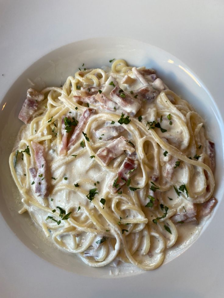 a white plate topped with pasta covered in sauce