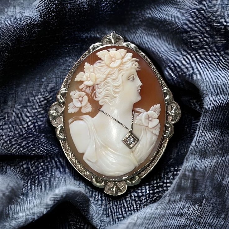 This Is A Very Lovely Example Of Beautiful Antique Jewelry Circa 1910. It Is An Intricately Carved Cameo Portrait Of A Beautiful Young Woman In Profile With Flowers In Her Flowing Hair And A Matching Floral Design On The Side Of Her Dress. She Is Wearing A Genuine Diamond Necklace. Stamped 14k White Gold The Gold Frame Is Ornate And Exquisite In Detail And Design. Measures 2 1/4” By 1 3/4" And Is In Excellent Original Condition. This Is An Exquisite Example Of An Elegant Bygone Era. Antique Cameo Brooch, Cameo Brooch, White Gold Diamonds, Gold Frame, Antique Jewelry, Diamond Necklace, Vintage Jewelry, Floral Design, White Gold