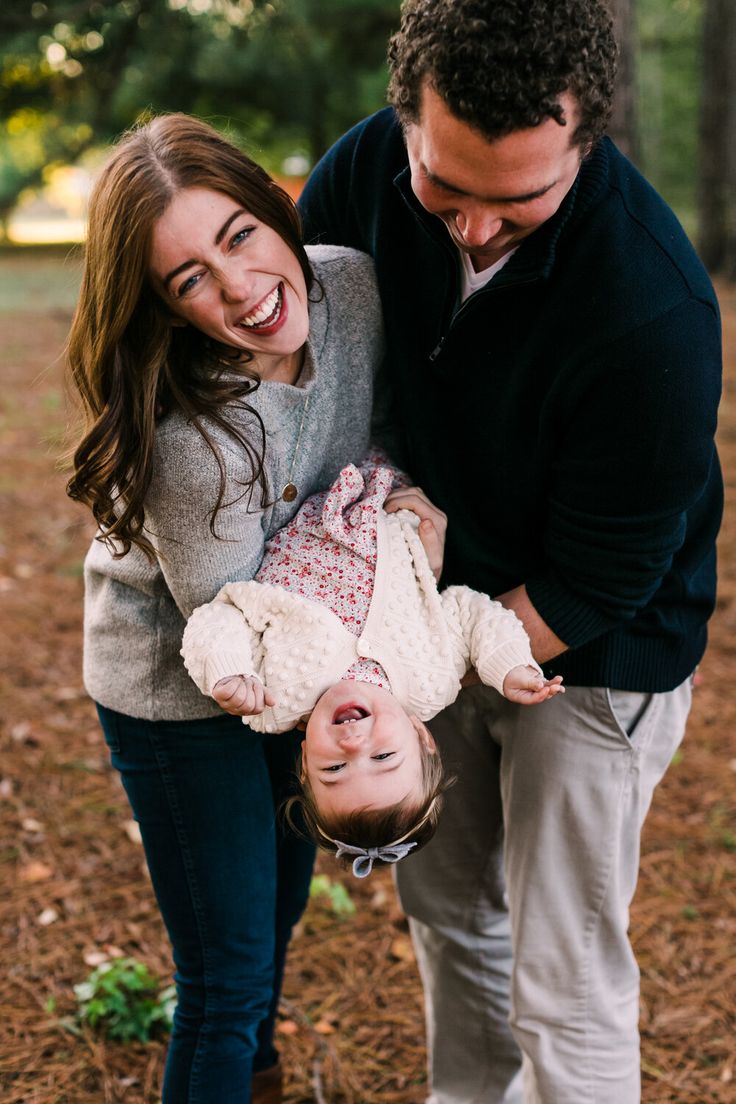 a man and woman holding a baby in their arms