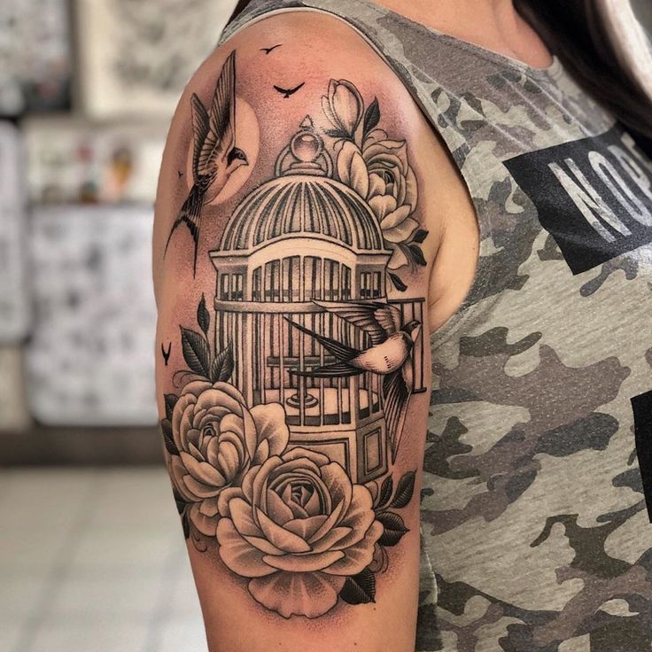 a woman with a birdcage and roses tattoo on her arm