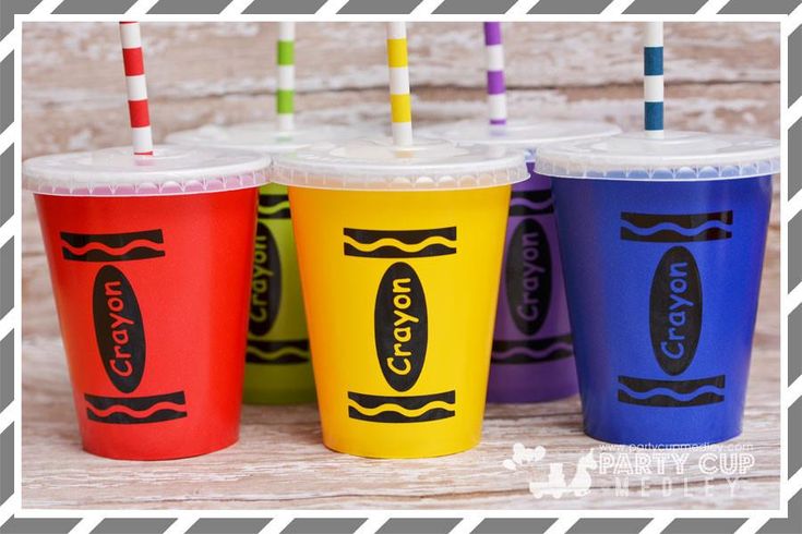 four different colored cups with straws in them on top of a wooden table next to each other