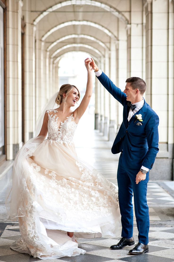 a bride and groom dancing together in an archway