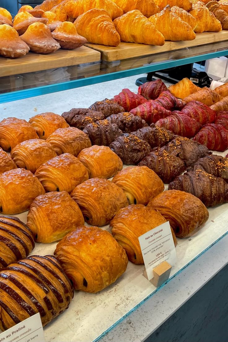 croissants and other pastries on display in a bakery