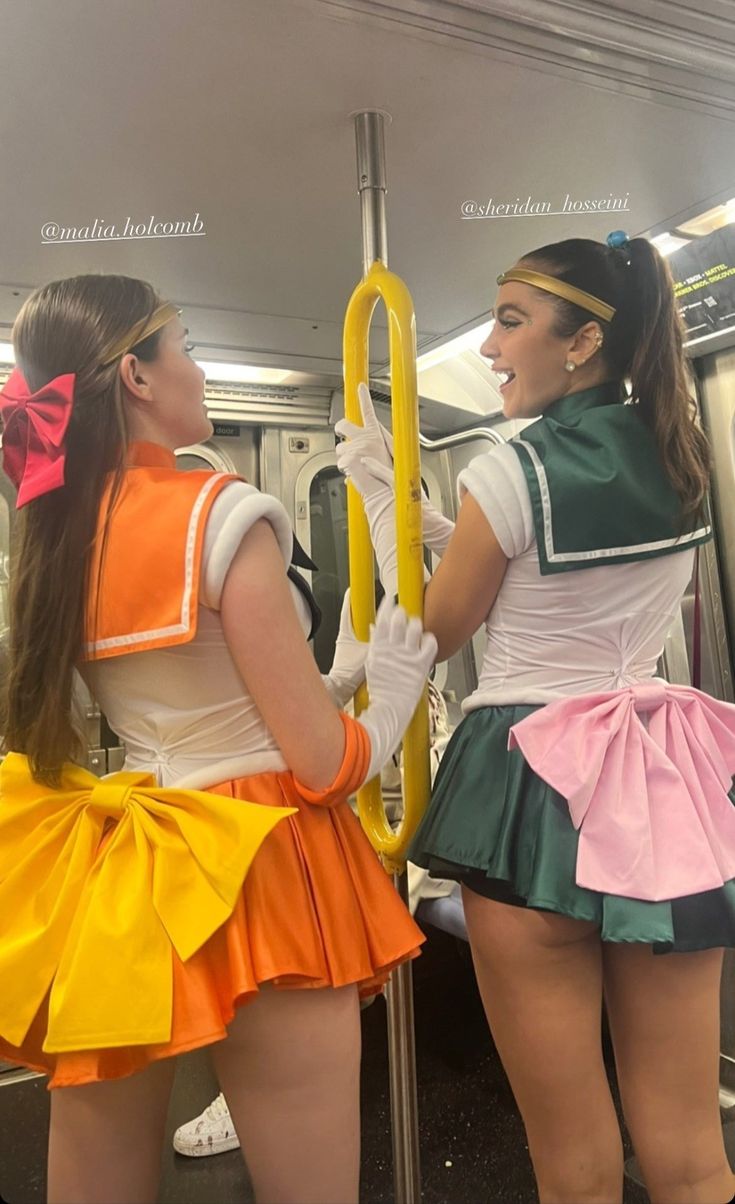 two women dressed in costumes on a subway