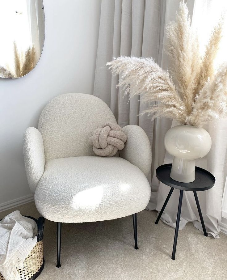 a white chair sitting next to a round mirror