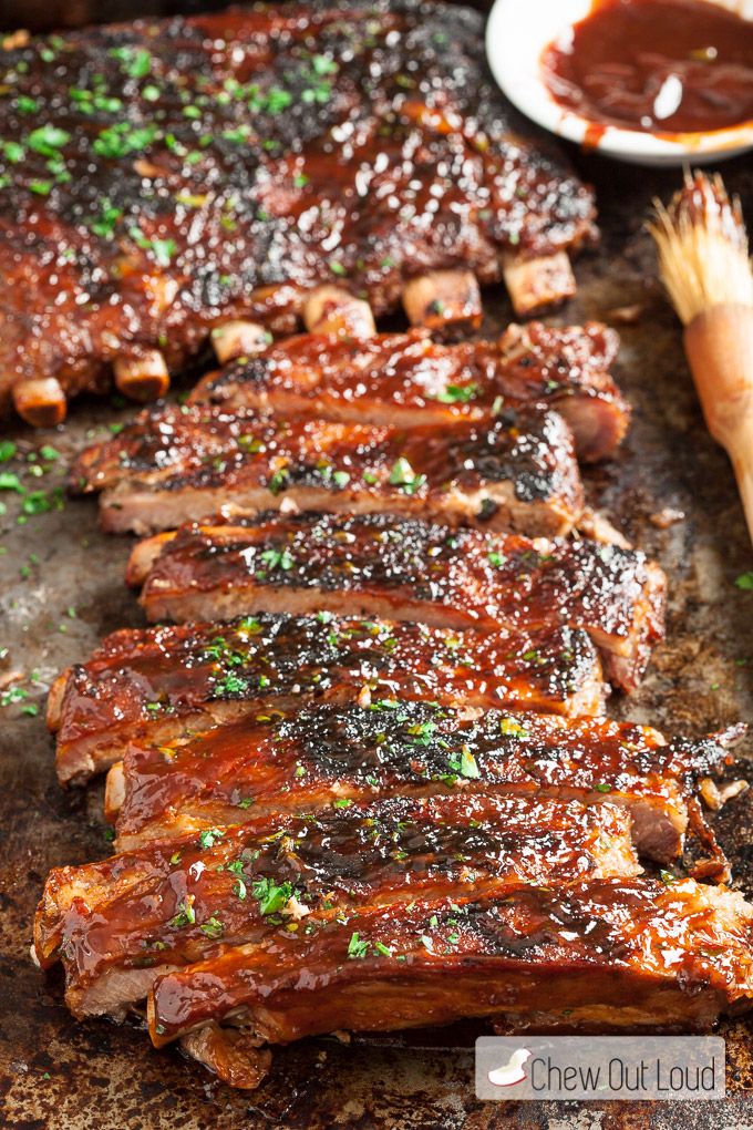 barbecue ribs with sauce and parsley on a baking sheet