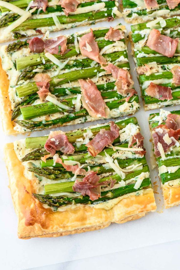 asparagus and prosciutto pizza cut into squares on a white surface