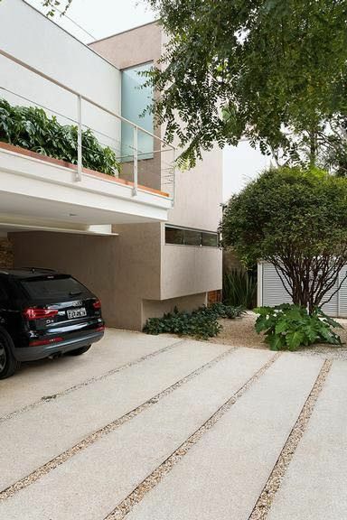 a black car parked in front of a house with stairs leading up to the garage