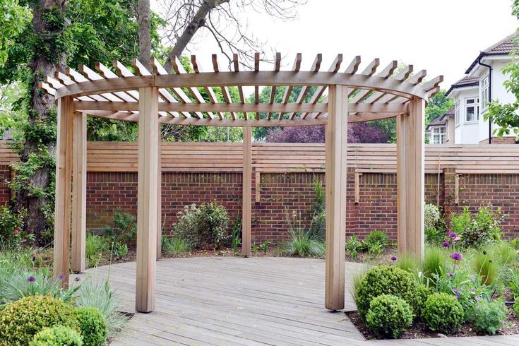 a wooden pergolated area in the middle of a garden