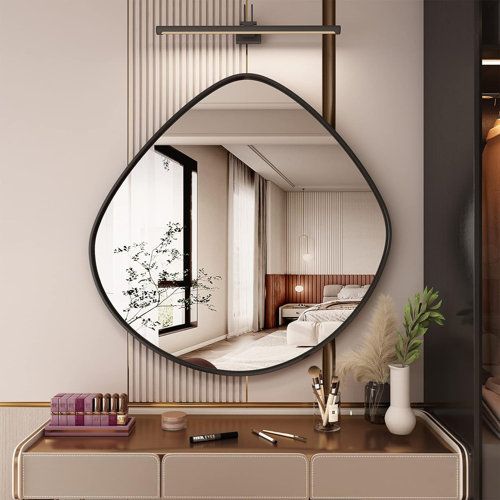 a mirror that is on the wall above a dresser