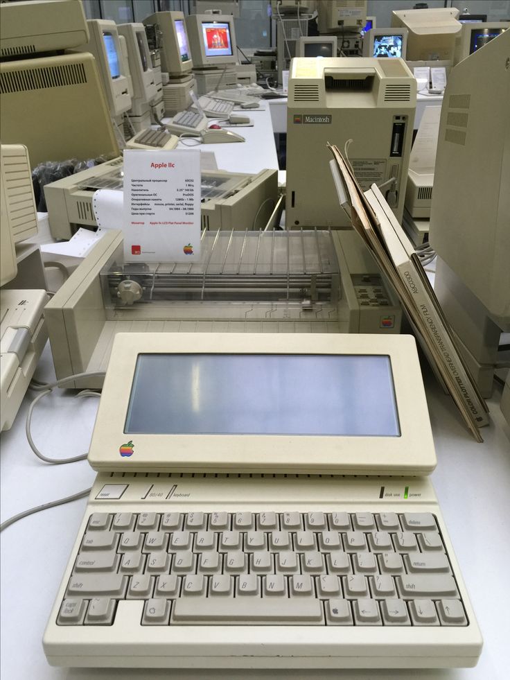 an old laptop computer sitting on top of a white table next to other electronic equipment