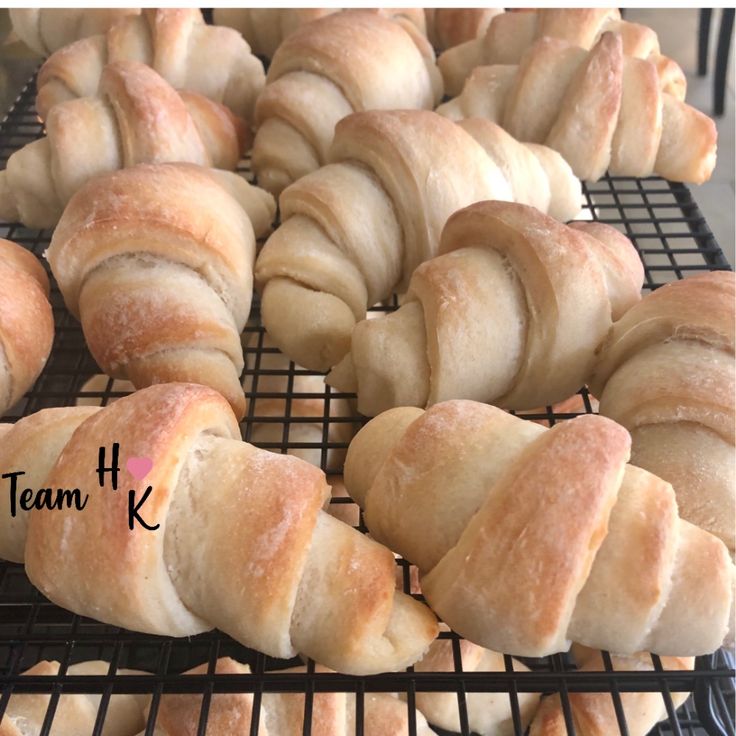 freshly baked croissants cooling on a wire rack with the words team k above them