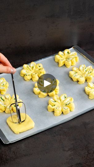 someone is decorating small pastries with yellow icing