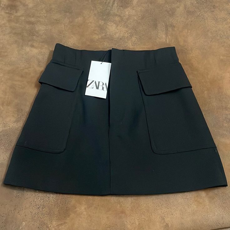 Zara Black Skirt. Brand New With Tags. Has 2 Covered Pockets. Size S. May Have A Lose Thread Or String Here Or There. See Pictures For Measurements. Ask Questions Before Purchasing. Trendy Zara Skirt For Workwear, Trendy Zara Mini Skirt With Pockets, High Waist Black Mini Skirt With Pockets, Zara Mini Skirt With Pockets, High Waist Black Skort With Pockets, Black Skort With Pockets, Black Skirt With Side Pockets, Zara Black Pencil Skirt, Office Mini Skort With Pockets