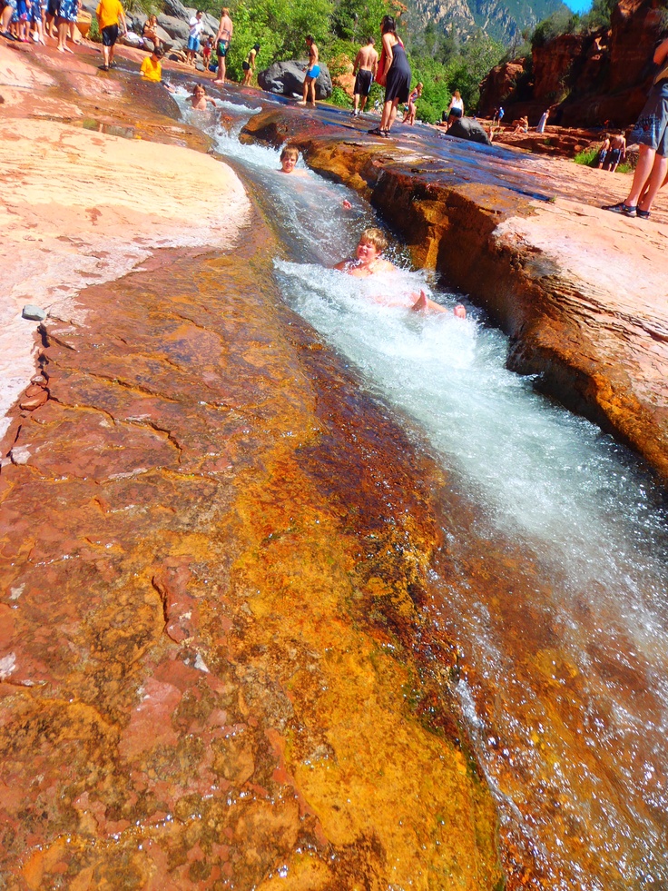 people are swimming in the water near some rocks