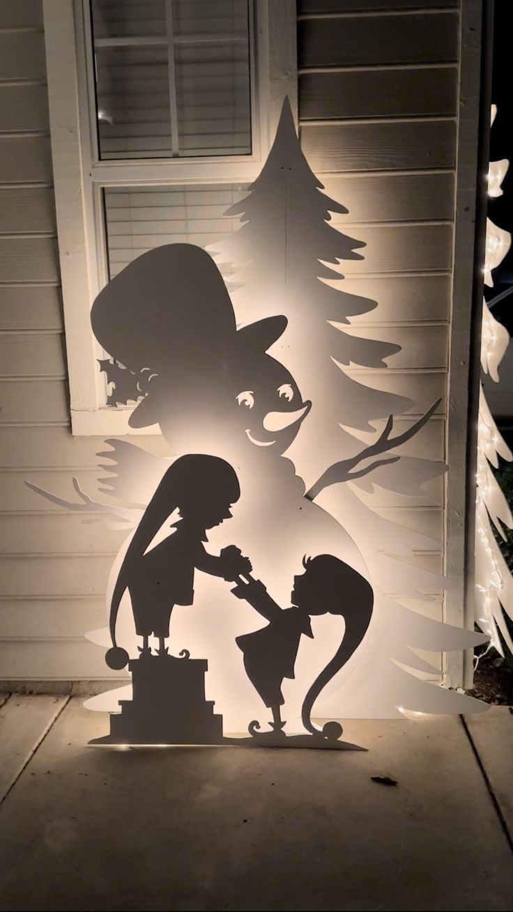 the silhouettes of two people in front of a house