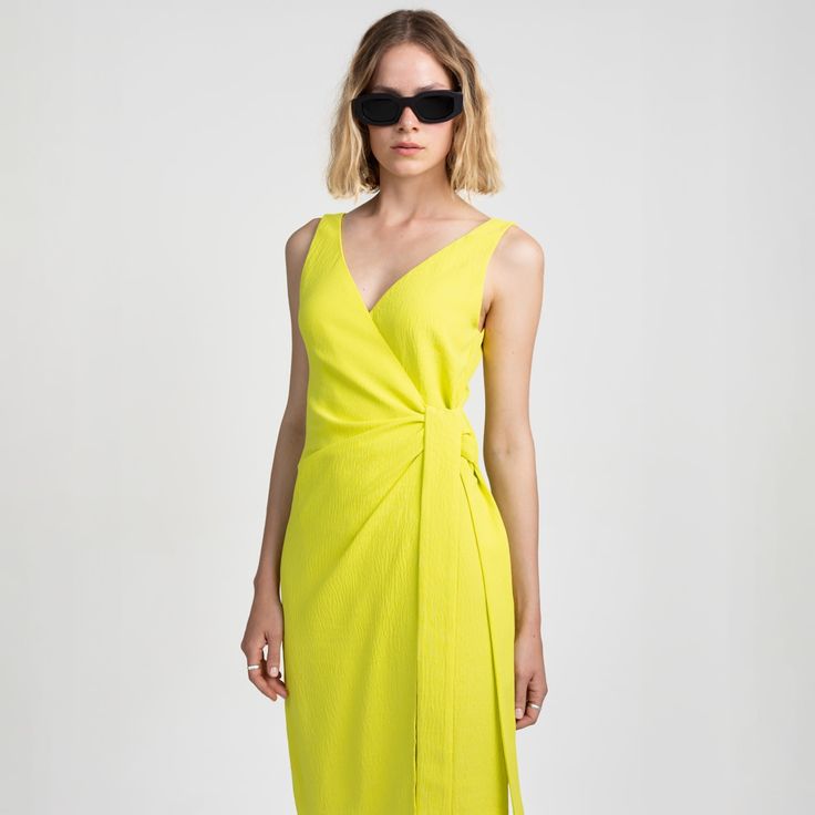 V-neck wrap dress in fluid, wrinkle-free fabric for casual and formal occasions. The vibrant neon colour adds a bold touch to your outfit and will make you stand out from the crowd. Featuring a stylish v-neckline and elongated side straps, this dress combines elegance with modern flair. 100% polyester  Made in Budapest.  Wash at or below 30°C. Do not bleach. Do not tumble dry. Iron at low temperature (110 °C). Modern V-neck Spring Dresses, Summer Formal Draped Wrap Dress, Summer Draped Wrap Dress, Draped V-neck Dress For Spring Evenings, Fitted Draped Wrap Dress For Summer, Spring Evening Draped V-neck Dress, Spring Evening V-neck Draped Dress, Modern V-neck Midi Dress For Spring, Modern V-neck Summer Dress