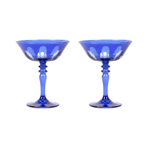 two blue glass goblets sitting side by side on a white background, one is empty