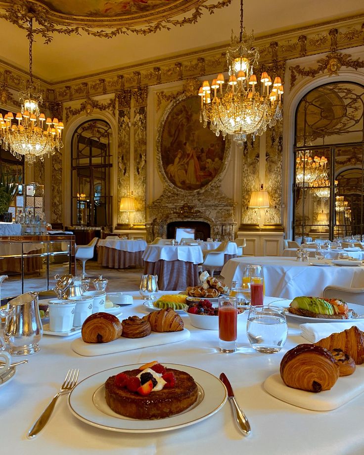 a dining room with white table cloths and fancy chandeliers