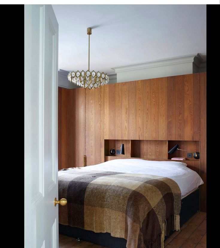 a bedroom with wood paneling and a bed