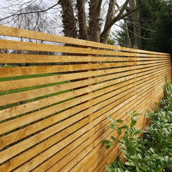 a wooden fence in front of some bushes