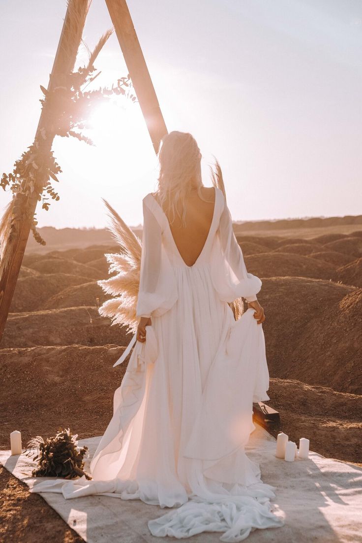 a woman sitting on top of a blanket in the desert