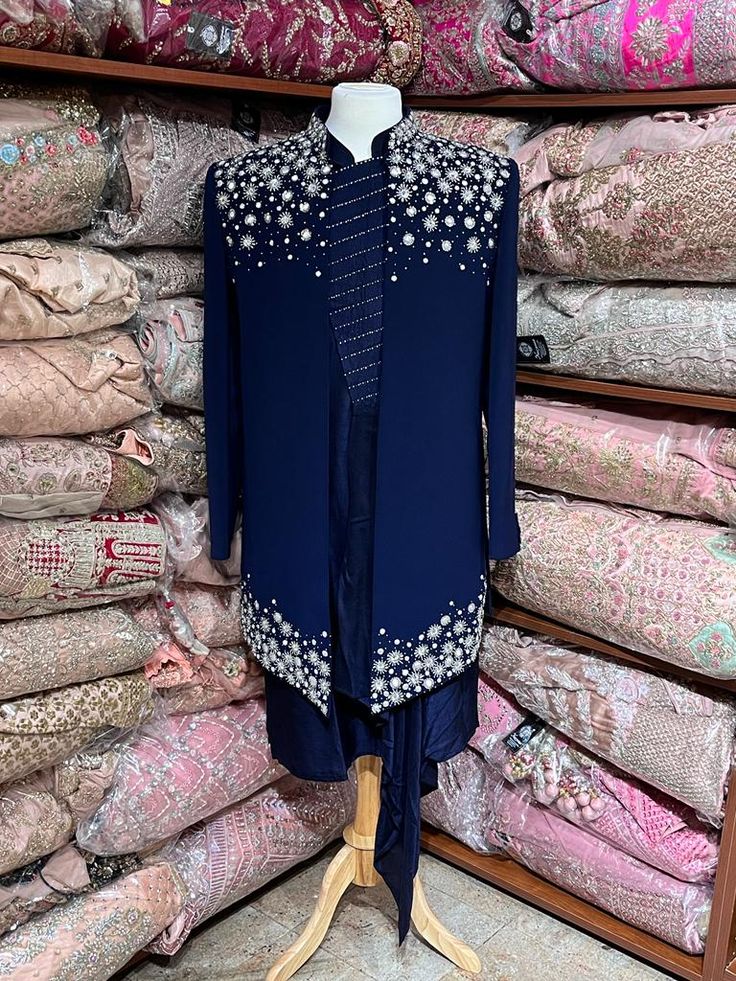 Midnight blue exclusive embellished with intricate pearl, stone, zari and cutdana work, this sherwani speaks volume of class. Commingled with blue color kurta for the complete ensemble. This jacket sherwani is a unique style that we loved. Even the color is fresh and looks royal. Size: 42,44 Occasion: Wedding Ceremony or Reception WASH CARE INSTRUCTIONS - Please Dry clean only when it is applicable. Slight color variation is possible due to digital photography. Ready to Ship! Designer Embellished Kurta For Eid, Designer Blue Nehru Jacket, Designer Party Kurta With Mirror Work, Designer Bandhgala With Mirror Work For Eid, Formal Nehru Jacket With Mirror Work, Designer Blue Traditional Wear With Dabka Work, Designer Blue Nehru Jacket With Traditional Drape, Designer Blue Nehru Jacket With Zari Work, Designer Blue Nehru Jacket For Diwali