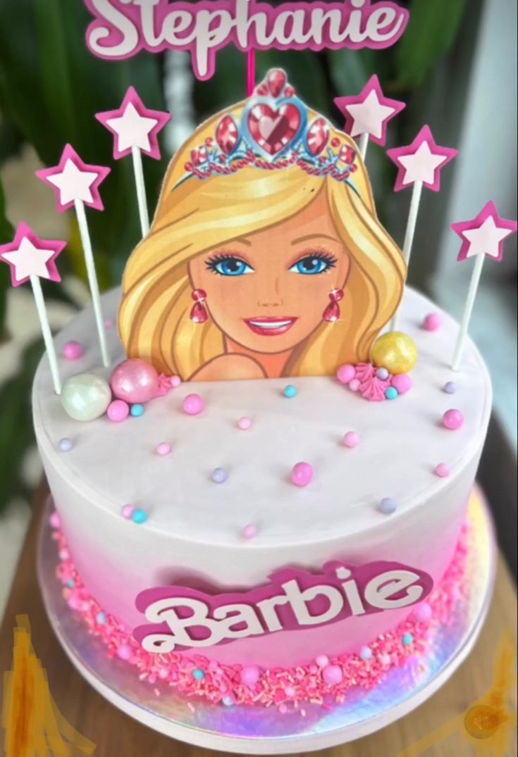 a birthday cake with a barbie doll on top and stars around the edges that says stephanie