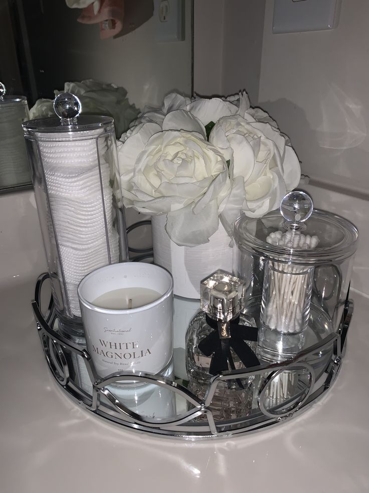 white roses and candles on a bathroom counter