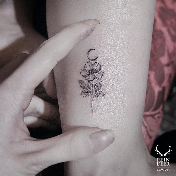 a woman's arm with a small flower tattoo on the left side of her body