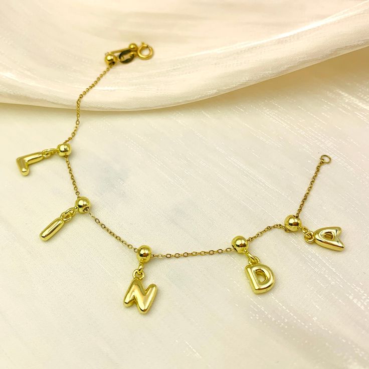 Get personal with the Minimalist Bubble Initial Bracelet! Make a statement with this sleek, gold charm bracelet adorned with bubble-style letters of your choice. The adjustable clasp guarantees a perfect fit for any wrist, so you can rock your initials or name in style. Perfect for adding a touch of individuality to your minimalist look.