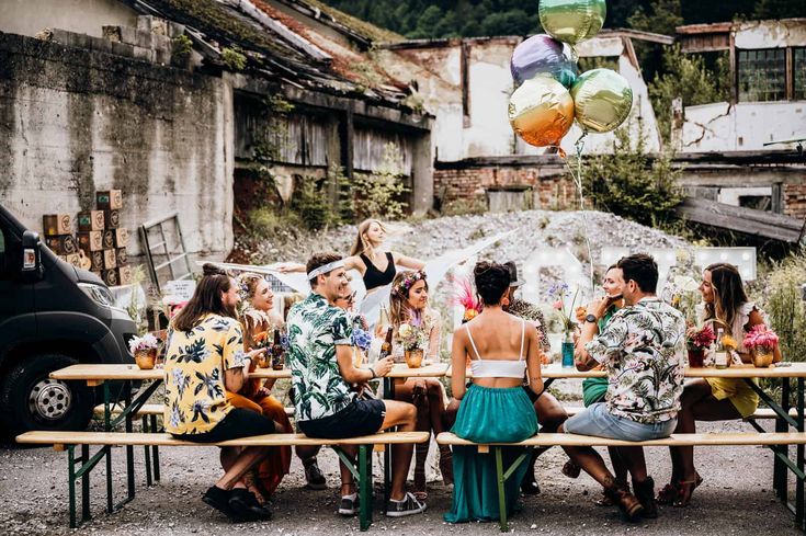 a group of people sitting at a table with balloons