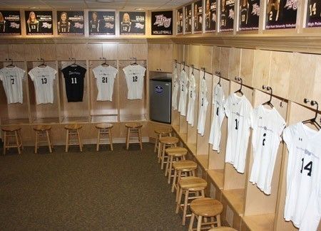 the locker room is filled with white shirts and stools for baseball players to sit in